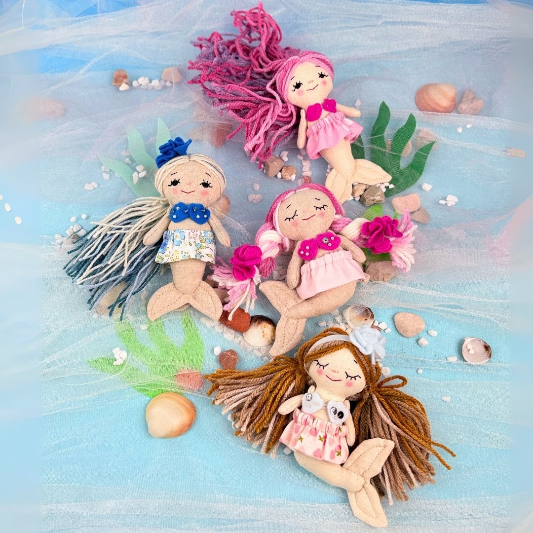 Set of mermaid dolls with colorful hair on a beach-themed background
