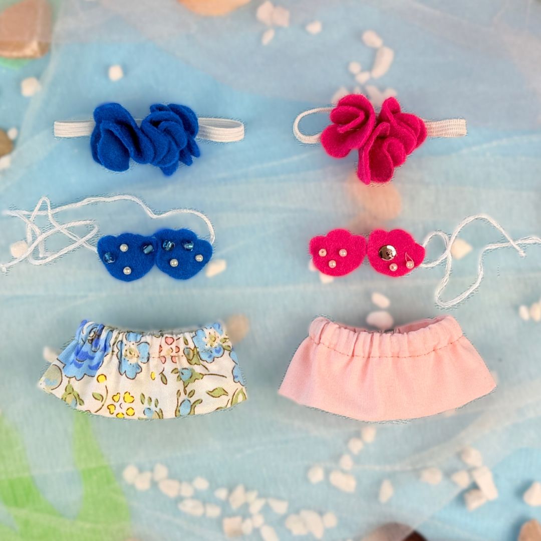 Set of colorful baby accessories including headbands and a skirt on a blue background.