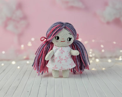 Create your own 5.5” Miniature Fabric Doll with Dress using the easy-to-follow PDF sewing pattern from Stella Pattern Studio. This delightful rag doll is perfect for dollhouses and can wear a variety of outfits, making her ideal for imaginative play.