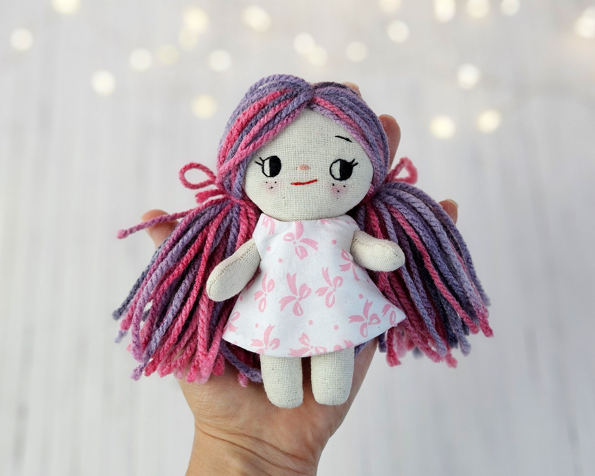 Create your own 5.5” Miniature Fabric Doll with Dress using the easy-to-follow PDF sewing pattern from Stella Pattern Studio. This delightful rag doll is perfect for dollhouses and can wear a variety of outfits, making her ideal for imaginative play.