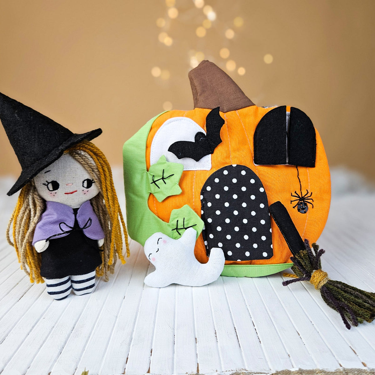Halloween-themed plush toy with a witch and pumpkin on a wooden surface.